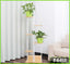 6-tier indoor flower rack display stand with green potted plants beside a sofa