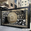 Modern CNC cutting boundary gate with intricate black and gold geometric design, outdoor setting