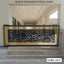 Modern CNC-cut metal boundary gate with black and gold floral patterns at building entrance