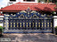 Ornate blue and gold cast iron boundary gate with decorative floral patterns outside a house