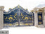 Black and gold decorative metal boundary gate with ornate patterns and columns outdoors