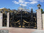 Luxury black and gold wrought iron boundary gate with ornate design, brick pillars, outdoor setting