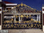 Decorative black and gold wrought iron gate with intricate floral and leaf designs, installed at a house entrance.