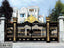 Luxury black and gold boundary gate with ornate design in front of a modern house