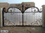 Decorative wrought iron boundary gate with ornate gold accents installed at a modern home exterior.