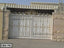 Decorative white metal boundary gate with gold accents installed at a house entrance