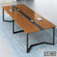 Modern wooden conference table with black metal legs on blue rug, minimal office setup