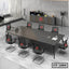 Modern conference room with large rectangular meeting table, eight black mesh chairs, and minimalist decor