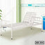 Adjustable steel hospital bed with crank, white frame, in a bright medical room