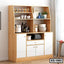 Wooden kitchen shelf with white cabinets, open shelves, jars, cookware, and appliances