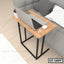 Wooden laptop table with black metal legs beside a sofa, ideal for home office setup