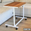 Modern wooden laptop table with white metal frame and wheels next to a sofa
