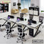 Modern office workstation setup with ergonomic chairs, computers, and sleek desks