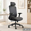 Black ergonomic office chair with mesh back, adjustable armrests, and headrest in modern workspace