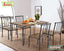 Modern dining table set with four wooden chairs, metal frames, tabletop decor, and fruit bowl