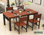 Modern wooden dining table set with four chairs in a bright, stylish living room.