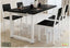 Modern black and white dining table set with four chairs in a bright dining room