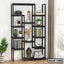 Modern black metal bookshelf with decorative items, books, and plants by a window