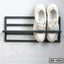 Wall-mounted black metal shoe rack with a pair of white sneakers, model SR-1004