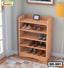 Wooden four-tier shoe rack with multiple pairs of shoes, placed in an entryway corner