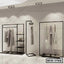 Modern standing closet organizer with black metal frame, shelves, and hanging clothes in a showroom