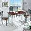 Modern steel dining table set with wooden top and four matching chairs in a bright dining room.