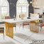 Modern steel dining table with gold legs and cream top in a stylish dining room
