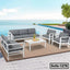 Modern outdoor steel sofa set with gray cushions by a pool and ocean view