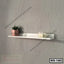 Modern white wall shelf with potted plant, candles, and eyeglasses against a gray wall