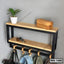 Modern wall shelf with black metal frame, wood shelves, hooks, and decorative items
