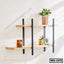Modern wooden wall shelf with black metal brackets, decorated with plants and candle, ideal for home or office.