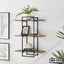 Modern wall-mounted shelf with black metal frame, wood shelves, decorative items and books.