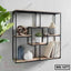 Modern geometric wall shelf with wood and metal, styled with decor, books, and a plant