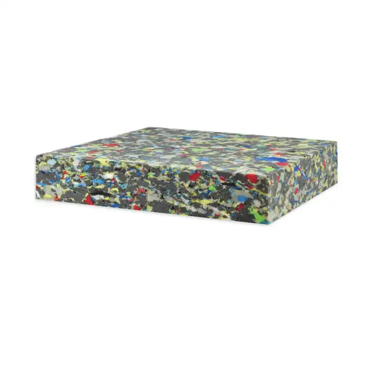 Rectangular block of multi-colored rebonded foam sheet on white background