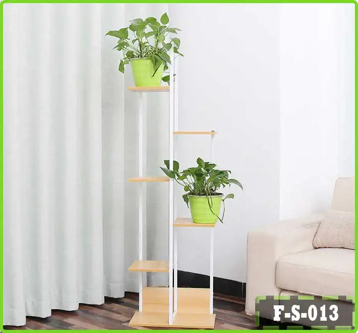 6-tier indoor flower rack display stand with green potted plants beside a sofa Main image