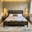 Modern metal and wood bed with geometric bedding, bedside tables, and pendant lights in a cozy bedroom