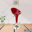 Modern red bar stool with chrome base and footrest on a mat floor, indoor setting