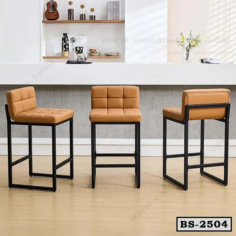 Set of three modern bar stools with tan cushioned seats and black metal frames in a home kitchen