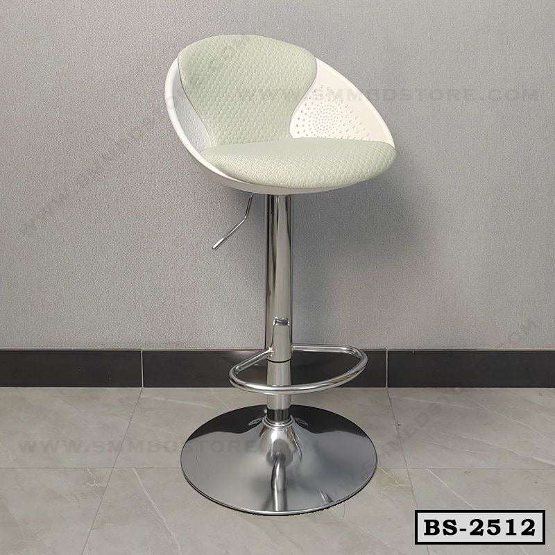 Modern adjustable bar stool with round chrome base and light cushioned seat against grey wall