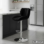 Modern black cushioned bar stool with chrome base at a marble kitchen island