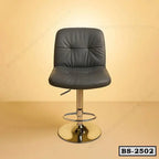 Modern black leather bar stool with chrome base on beige background, adjustable height chair