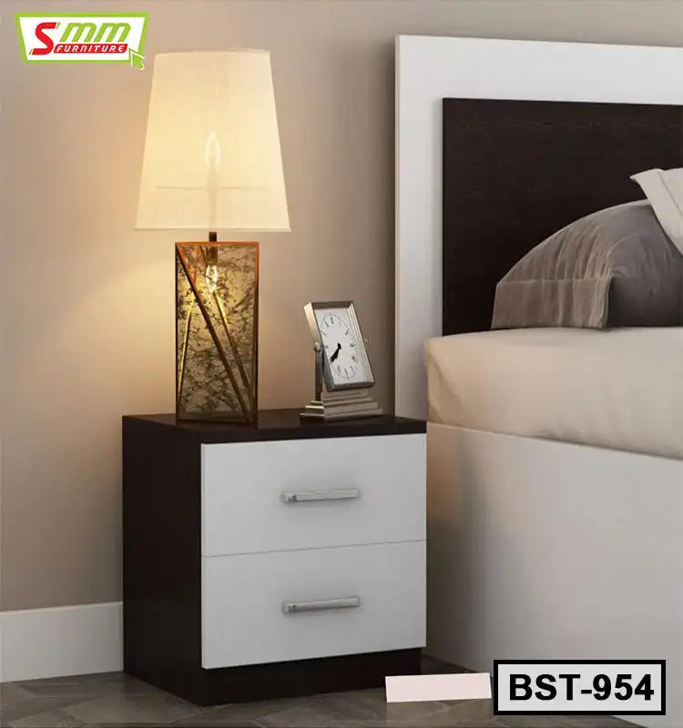 Modern bedside table with two drawers, table lamp, and clock next to bed in bedroom Main image