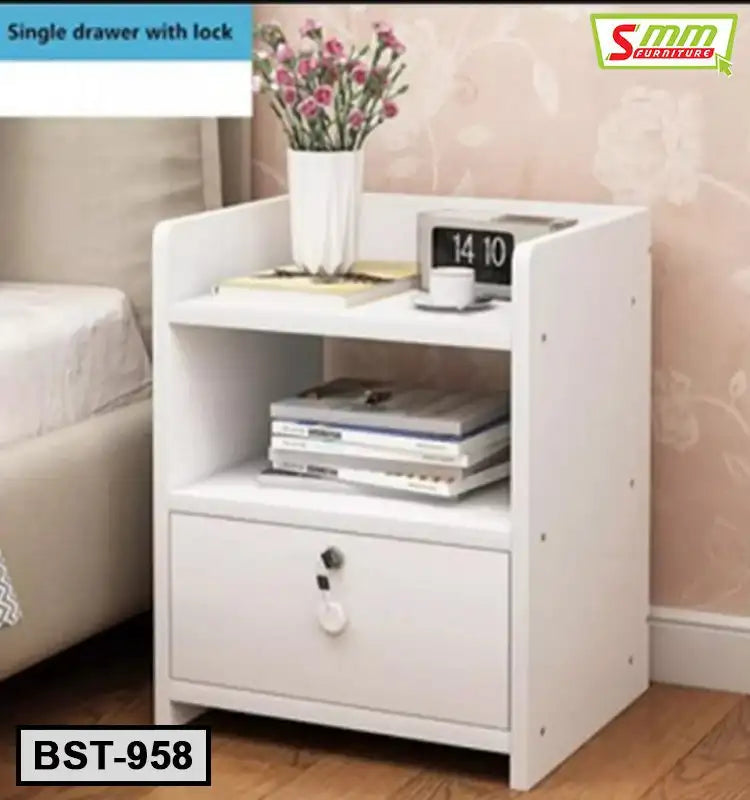 White bedside table with single locking drawer, open shelf, books, flowers, and digital clock. Main image