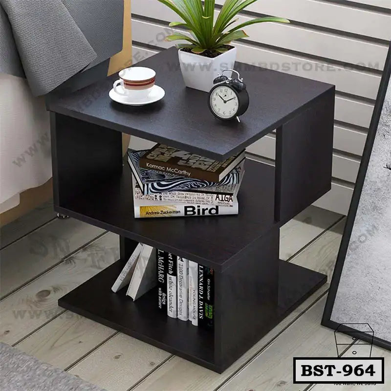 Modern dark wood bedside table with open shelves, alarm clock, plant, books, and cup