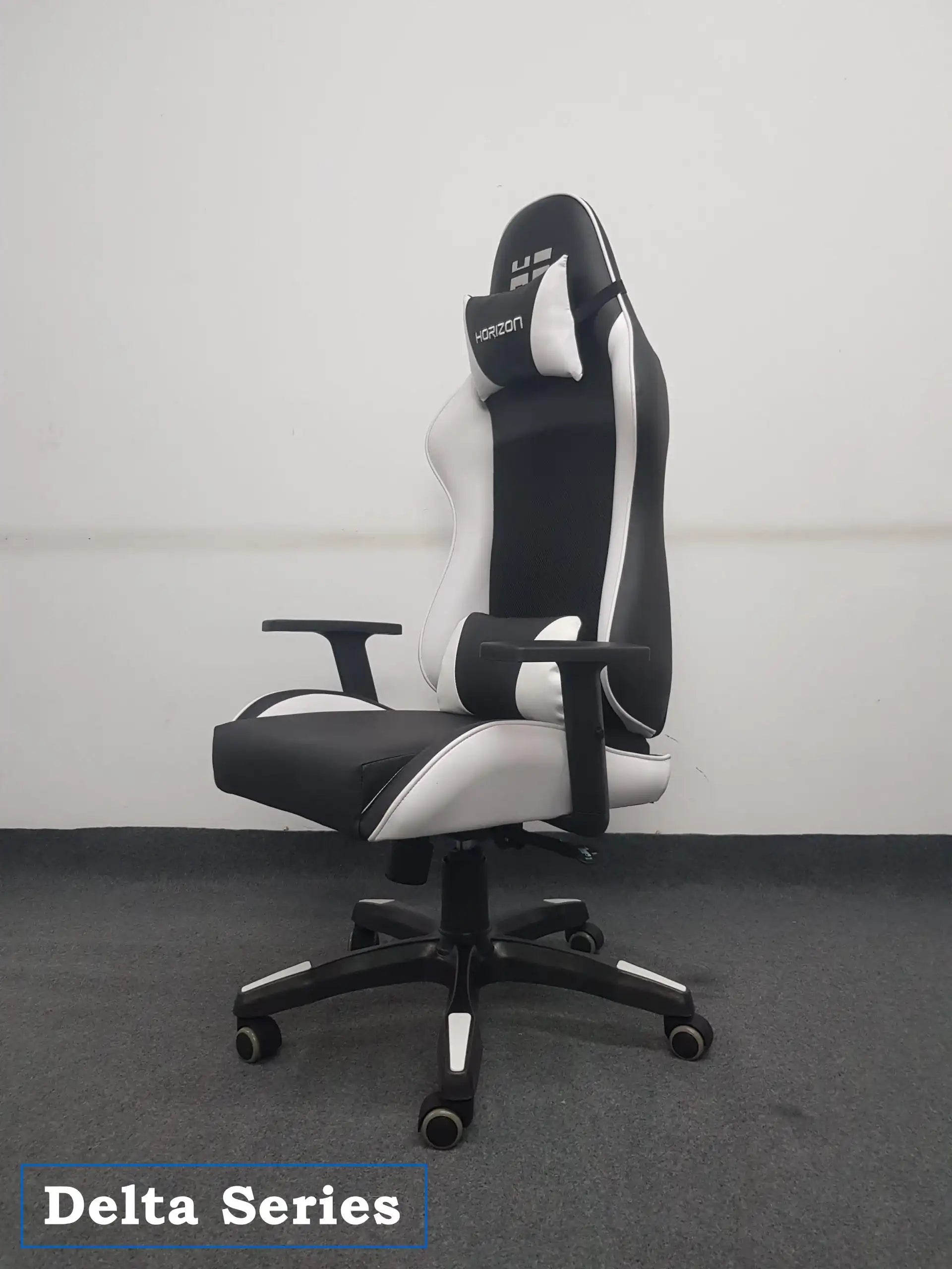 Black and white ergonomic Delta Series gaming chair with headrest and armrests on gray carpet