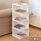 White modern bookshelf with four shelves, holding books, beside a beige sofa on wooden floor