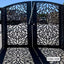 Modern CNC-cut metal boundary gate with floral pattern casting intricate shadows outdoors