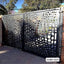 Modern CNC-cut metal boundary gate with abstract perforated design outdoors