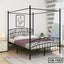 Modern black metal canopy bed frame with elegant scrollwork in a bright bedroom