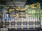 Ornate black and gold metal boundary gate with intricate floral patterns, outdoor setting